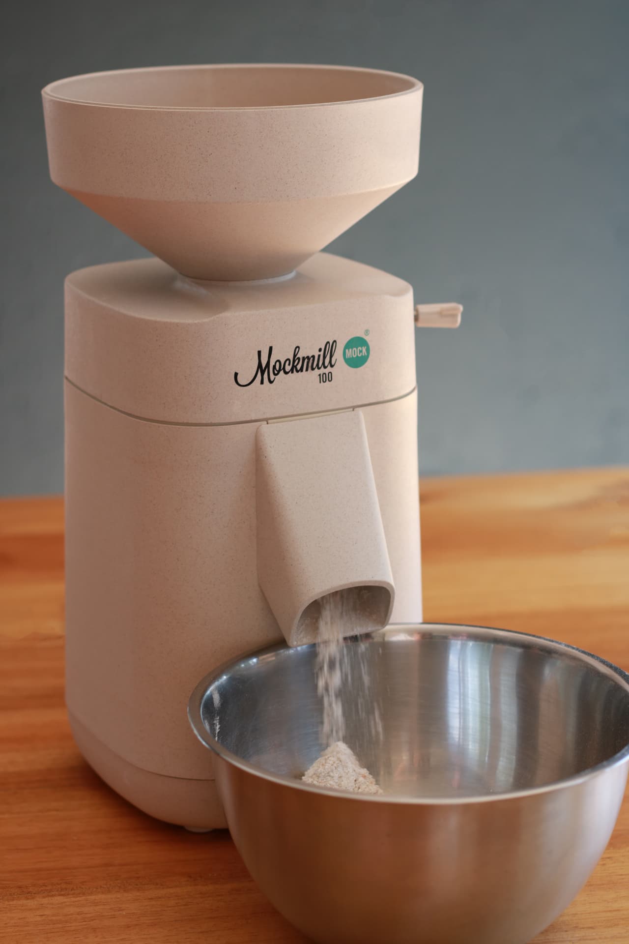 Mockmill grain mill milling fresh whole wheat flour into a bowl